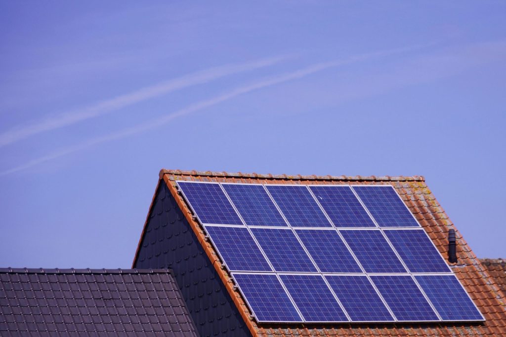 Coastal home with solar panels - an example of energy efficiency, a key principle of sustainable interior design.